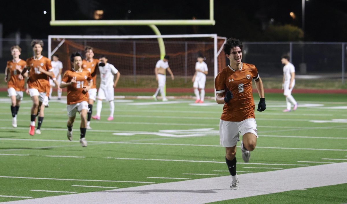With a proud smile, Rodrigo Garcia '26 celebrates his goal with his team right behind him. Garcia scored the third goal of the match for the Warriors.