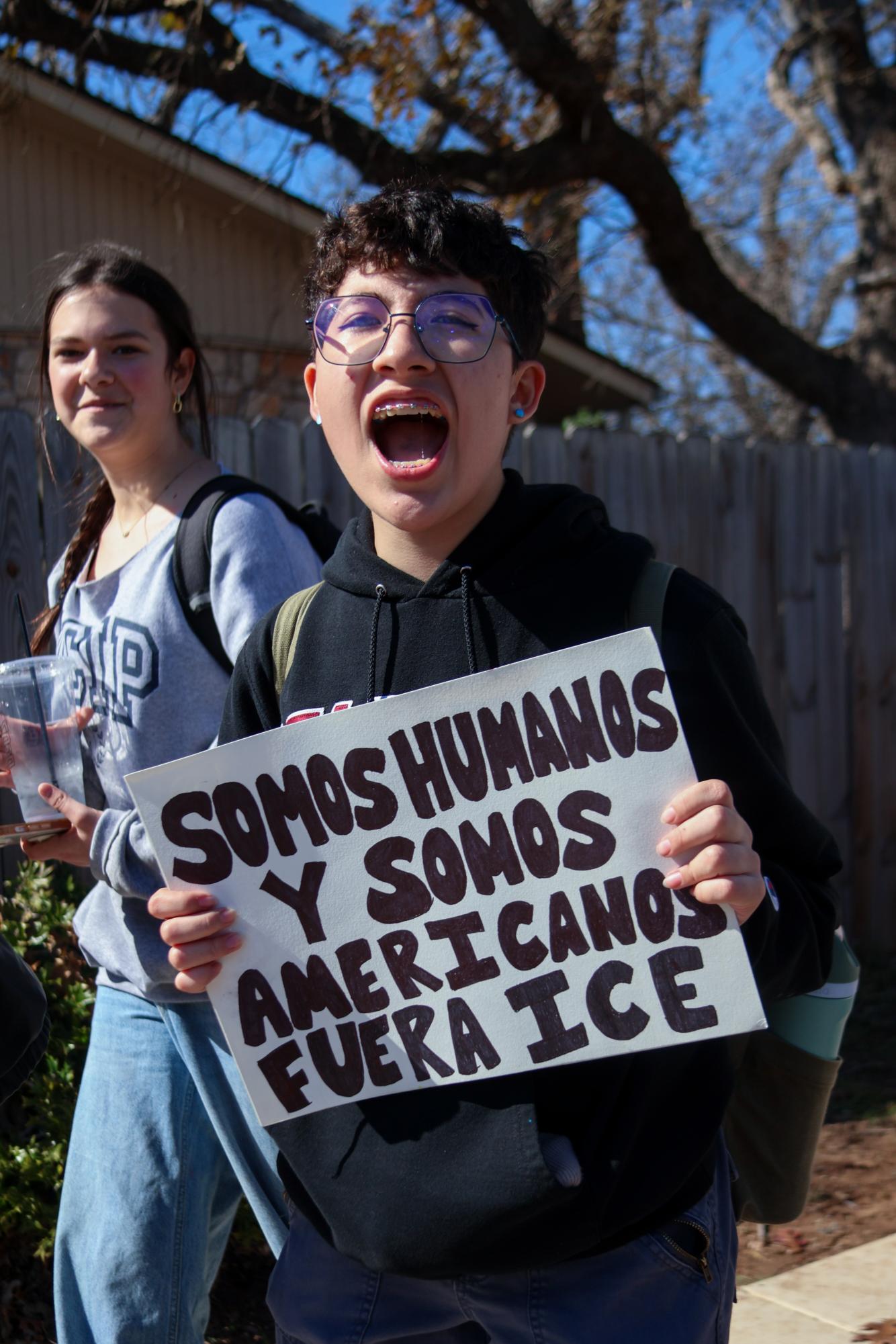 Holding a sign, Tyler Martinez '26 voices disdain for ICE. The words on the sign directly translate to "We are humans and Americans. ICE out," in Spanish. "[The walkout] made me feel like my voice was heard [and] that so many people agree that what ICE is doing is wrong," Martinez said. "It’s really nice to see the community come together and protest something we all agree on."