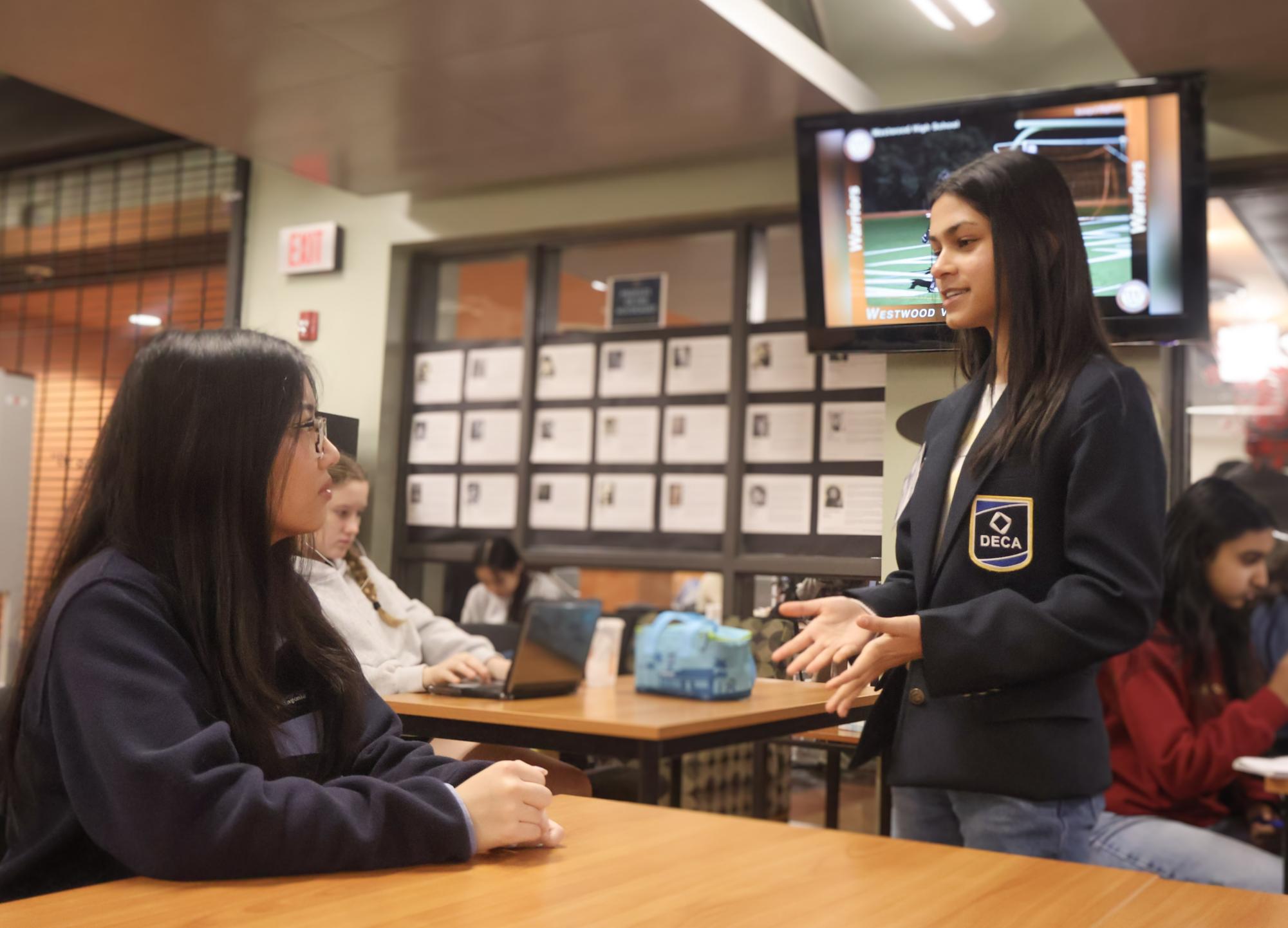 Brightly, Vandya Agarwal '28 explains her vision for Distributive Education Clubs of America (DECA) District 5 to a prospective member. Despite her young age, Agarwal's impressive composure and dedication to the program won her the seat of District 5 president. 