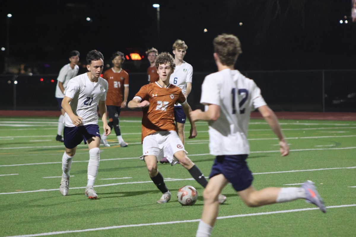 Running the ball back, Antoni Banka '27 looks for another way around the Maverick defenders. He assisted in scoring a goal for the Warriors.
