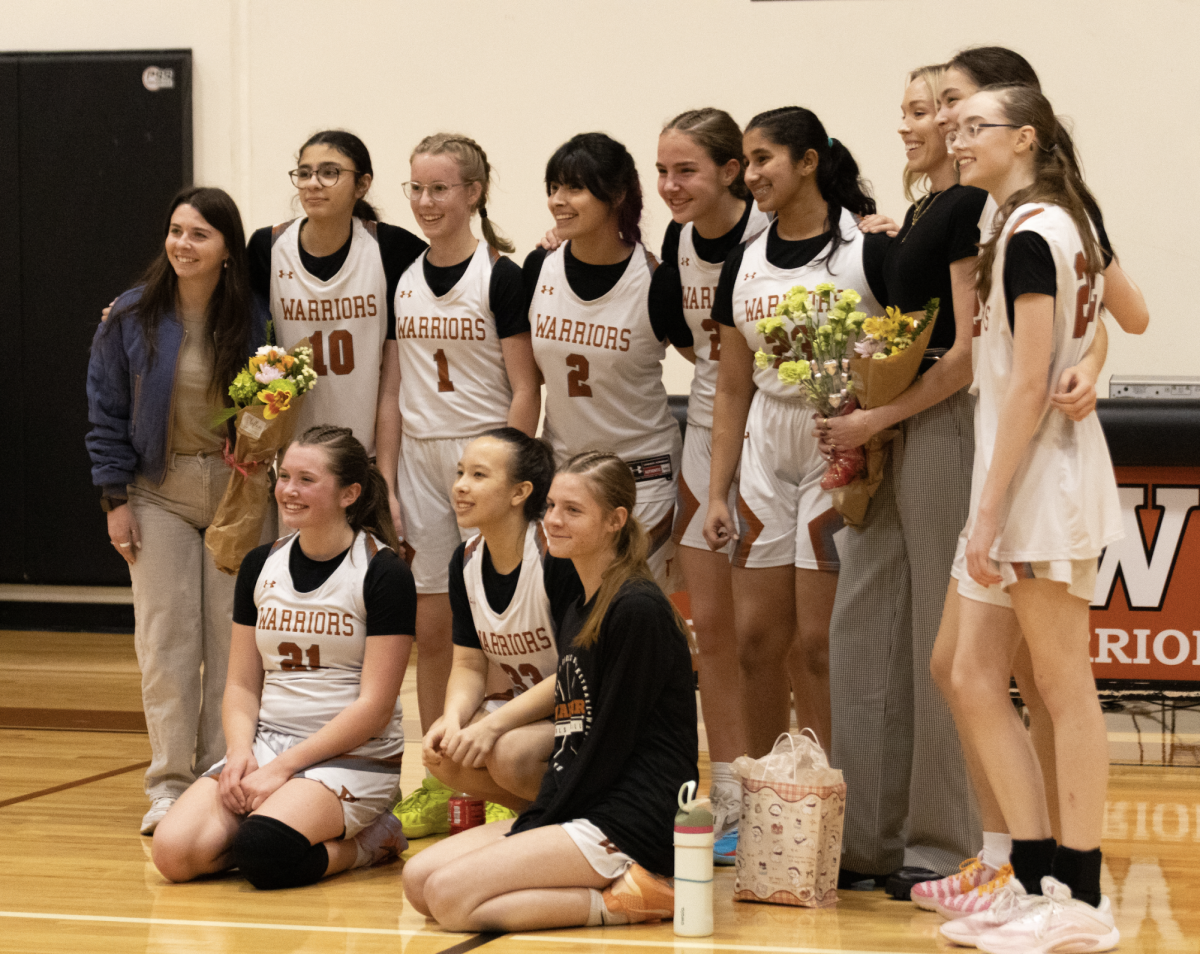 Posing for the cameras, the freshman girls' basketball team takes pictures right after the game. 