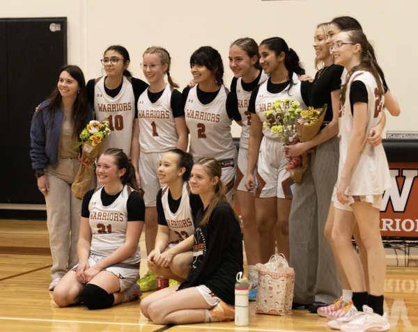 Posing for the cameras, the freshman girls' basketball team takes pictures right after the game. 