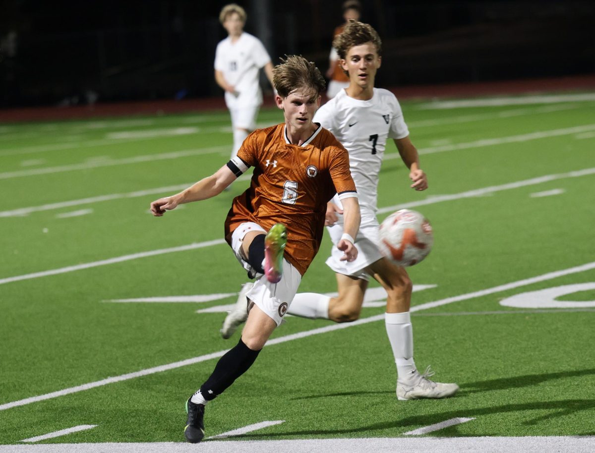 Sweeping the ball into the air and to a peripheral teammate, Jack Cox '26 swings his leg. To create speedy movement on the field, the Warriors employed a mix of long drives and bold passes to each another. 