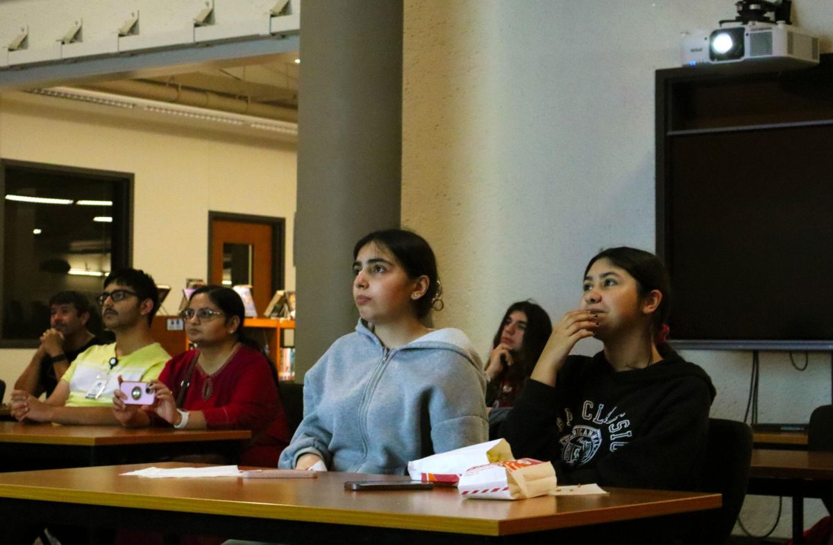Enjoying popcorn, sophomores Seljan Guliyeva and Tabatha Maldonado watch the screen during the Animation & Film Festival. Both of them came to support their friends' work. "It was really fun to see how many creative people we actually have in Westwood," Guliyeva said. "There's truly something beautiful growing within us, and I think we should support our art departments  more because they should receive a full credit for creating something beautiful." 