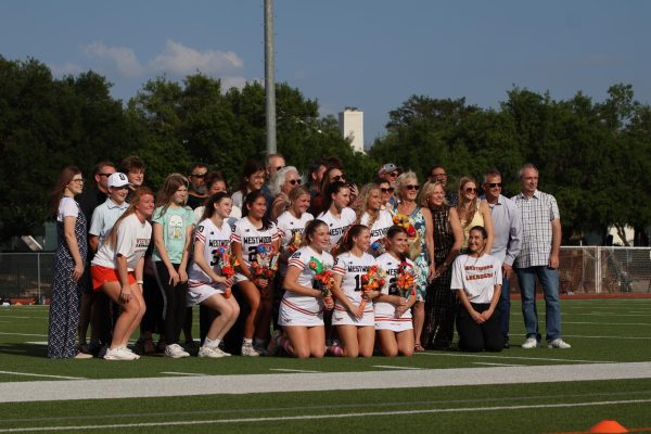 All smiles, the seniors on the Varsity Girl's Lacrosse get together for a photo. Surrounded by family, the girls were excited for their last game. 
