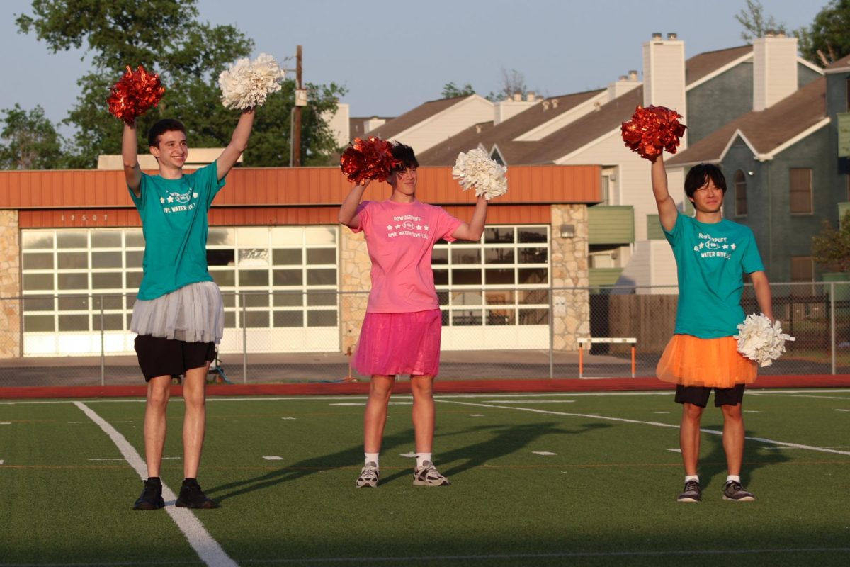 Smiling, Jackson Paddock '26, Nate Gundersen '27, and Richard Xue '26 wave at the crowd. Before the game began, each participating cheerleader was introduced to the audience.
