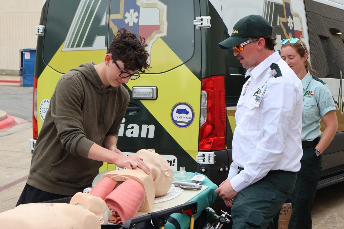 Checking for a pulse, Gabriel Bradley '26 practices recognizing symptoms for opioid overdose. The Emergency Medical Services (EMS) workers allowed each student to practice taking the proper steps on a mannequin, such as listening for breathing and checking for pinpoint pupils.