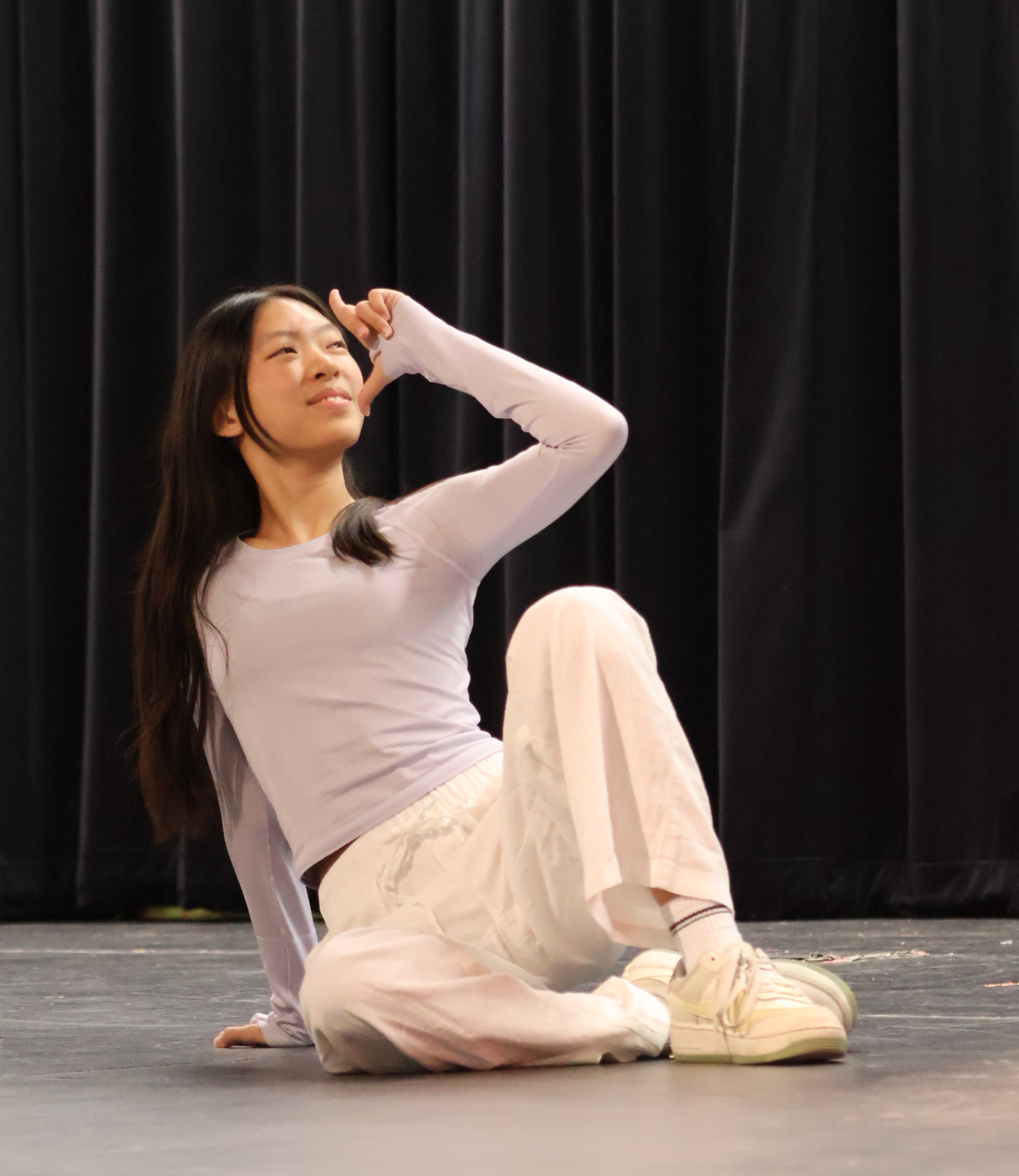 Finger pointed up, Bella Wen '28 strikes a pose during 'SPAGHETTI' by LE SSERAFIM. The dancers' synchronization and the audience's awe showcase the group's improvement in choreography and ability to charm a crowd.