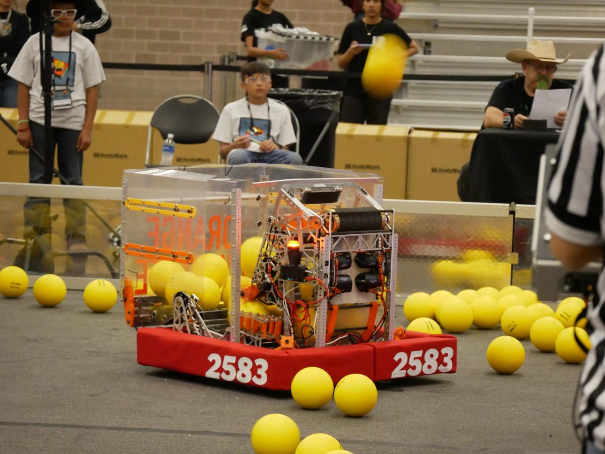 Surrounded by fuel, FRC Team Orange Dynamite's robot sits on the field after a match. By the end of the qualification matches, Orange Dynamite was ranked third, giving them the chance to choose their own alliance for playoffs. 
