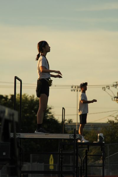 Standing on her podium, Cynthia Liu '26 conducts the band at a rehearsal during marching season. As a drum major for her junior and senior years, Cynthia learned a lot about being a leader and impacting the band for the better.