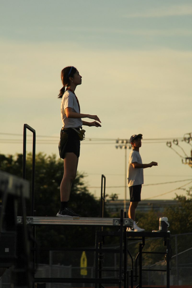 Standing on her podium, Cynthia Liu '26 conducts the band at a rehearsal during marching season. As a drum major for her junior and senior years, Cynthia learned a lot about being a leader and impacting the band for the better.