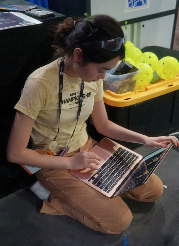 Concentrated, Yonnie Yang '27 looks through the slides the presentation team had created to prepare for Worlds. These slides were utilized throughout pit judging in order to point judges towards visual references for robot iterations, helpful design strategies, and more. 